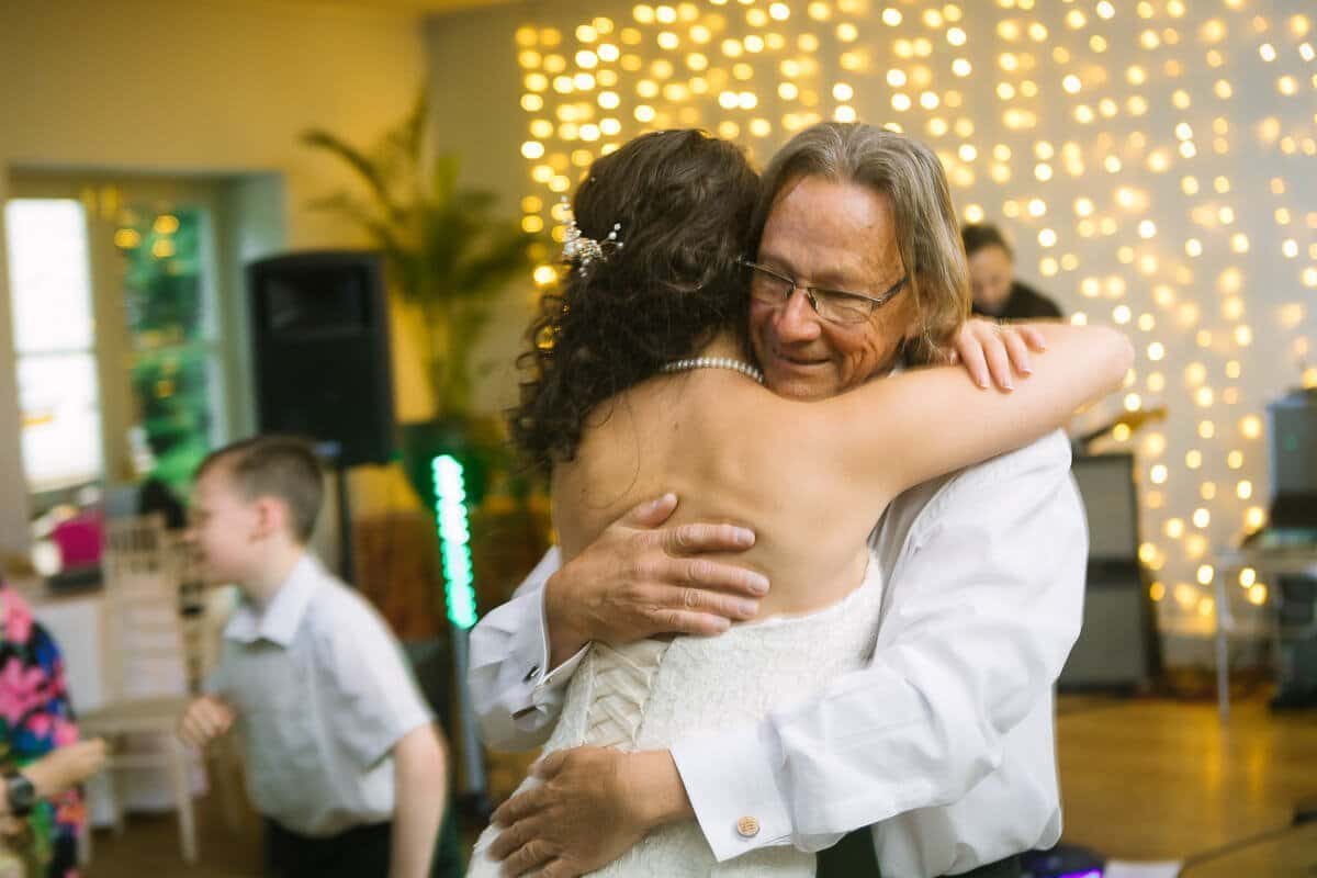 Father of bride hugging his daughter on the dance floor