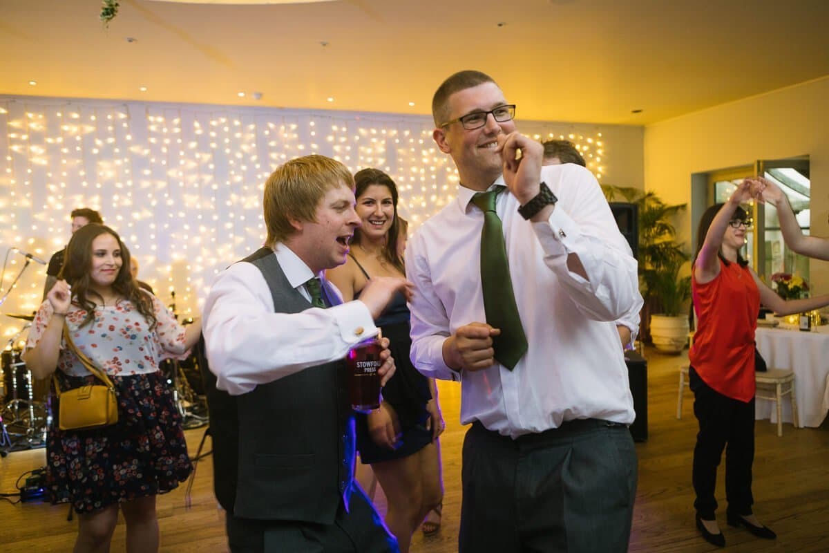 Groom and best man dancing at wedding reception