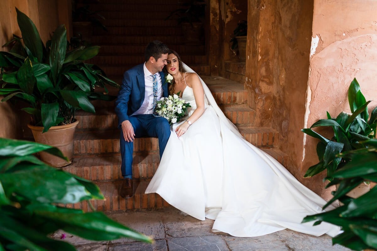 Portrai of bride and groom sitting on steps at Spanish wedding