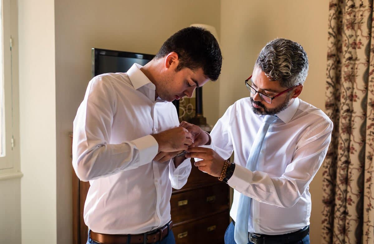 Bestman helps groom get ready at wedding