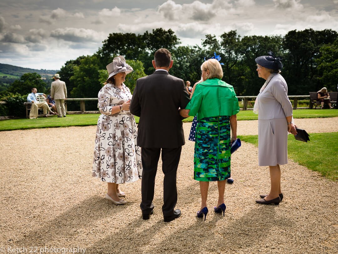 Wedding guests waiting and chatting on garden terrace just prior to ceremony at Whitney Court