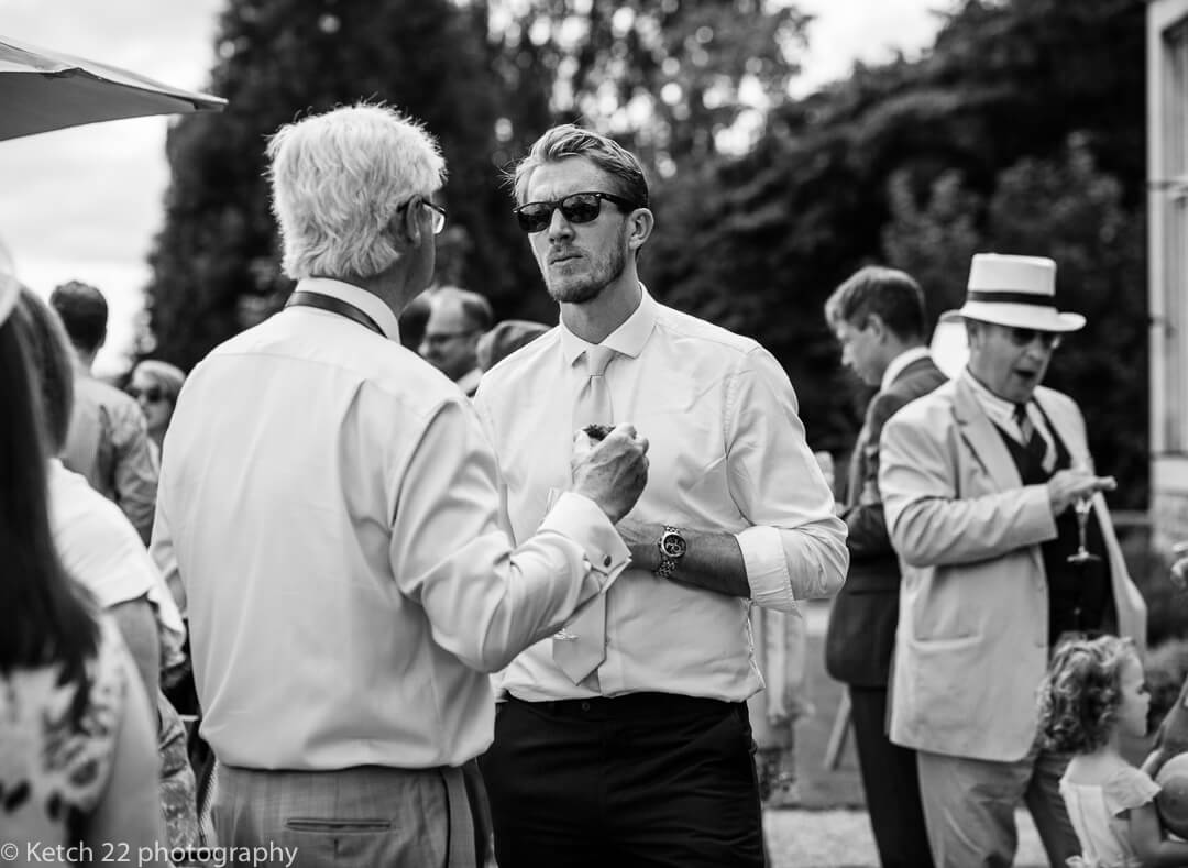 Wedding guests chatting on garden terrace