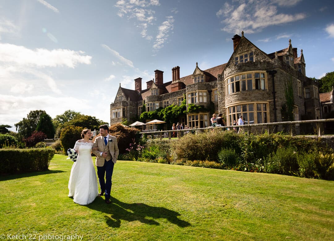 Bride and groom walk in font of venue at Whitney Court weddings