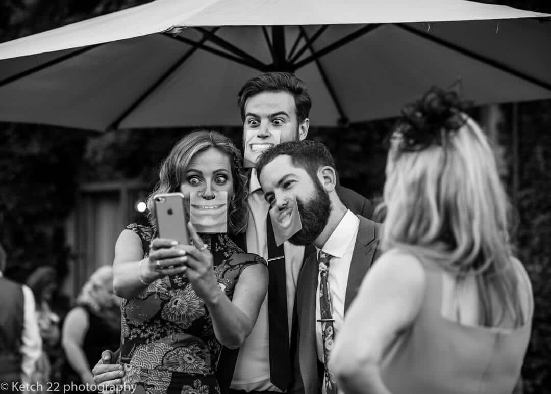 Wedding guests taking selfies with silly masks