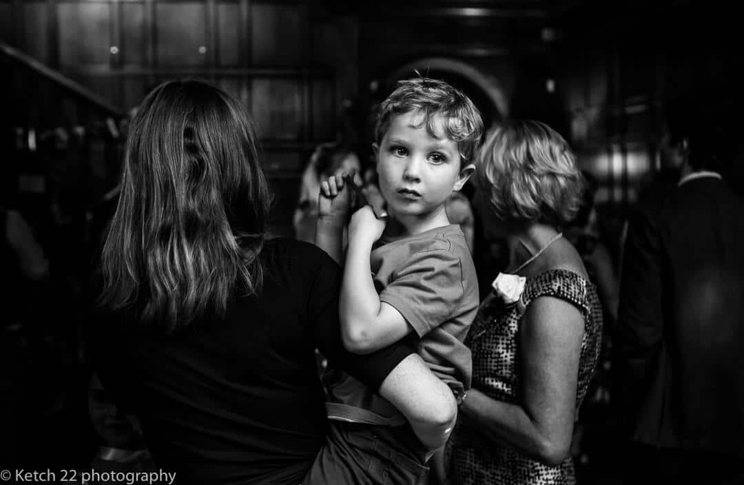 Black and white portrait of young boy at wedding reception