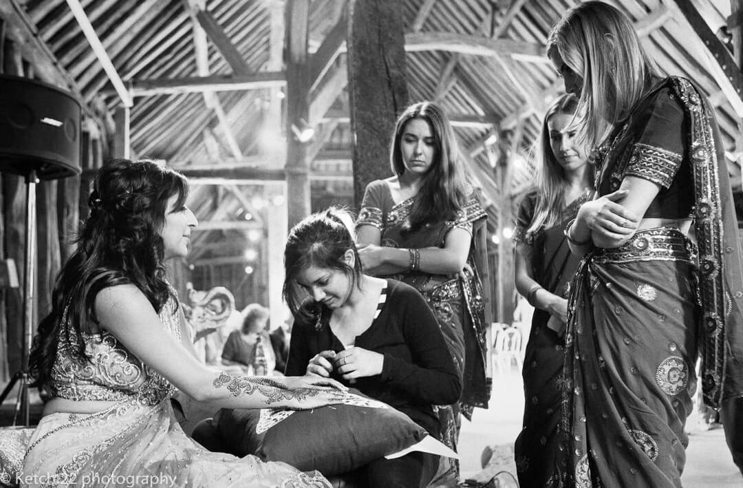 Hindu bride chatting to friends on Indian Henna evening in London