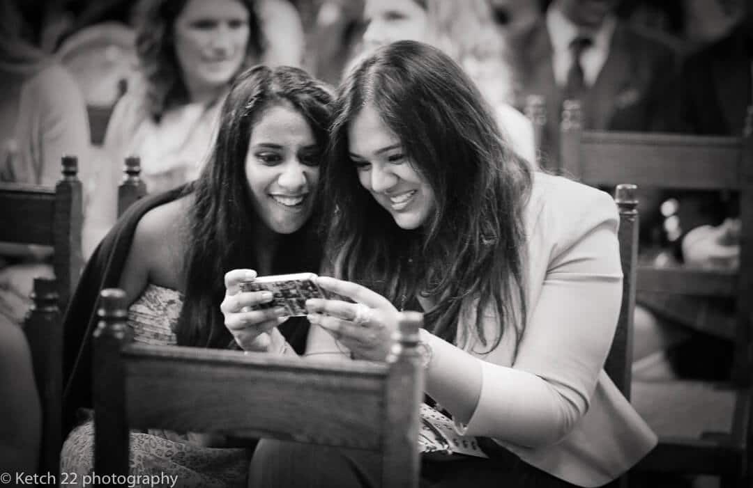Wedding guests looking at phone at Civil wedding ceremony in London