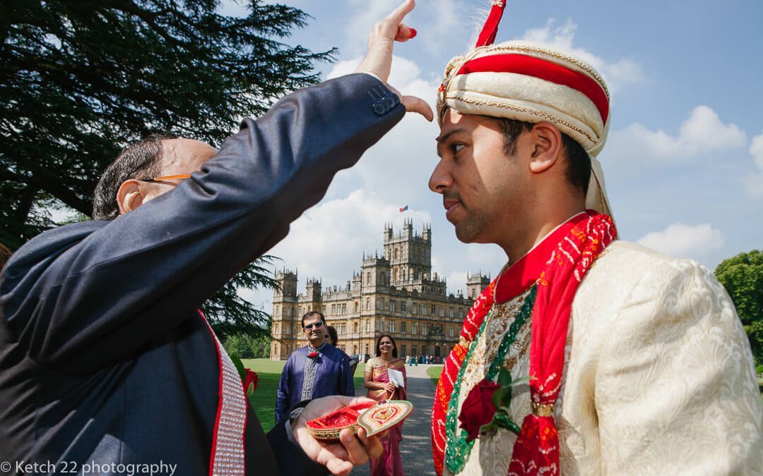 Groom in colourful hindu dress outside Castle