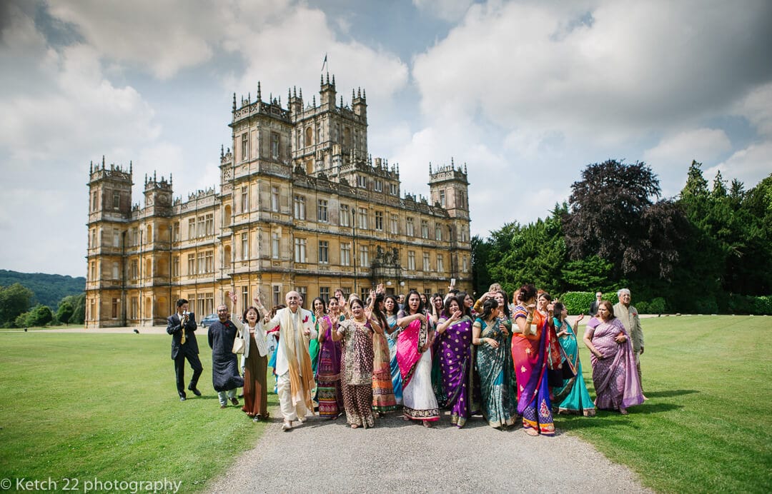 Wedding guests cheering in front of Highclere castle