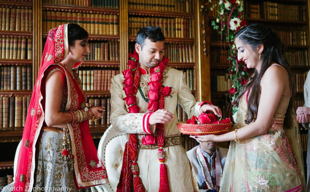 Groom receives red flowers at Highclere Castle