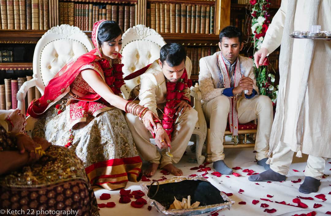 Bride and groom sprinkle dust on fire at Hindu wedding