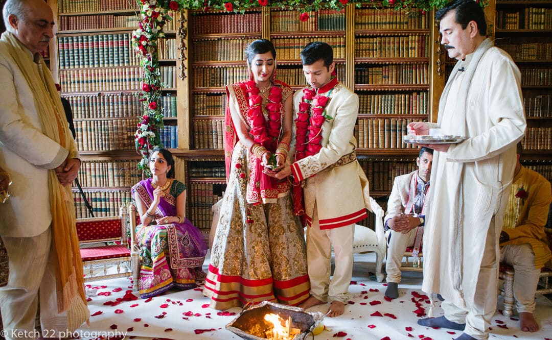 Bride and groom standing over fire at Indian wedding