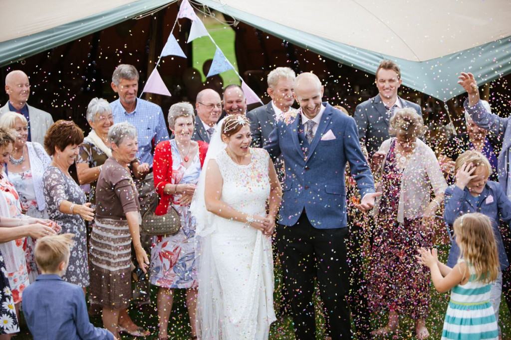 Wedding guests throwing confetti on bride and groom in Shropshire