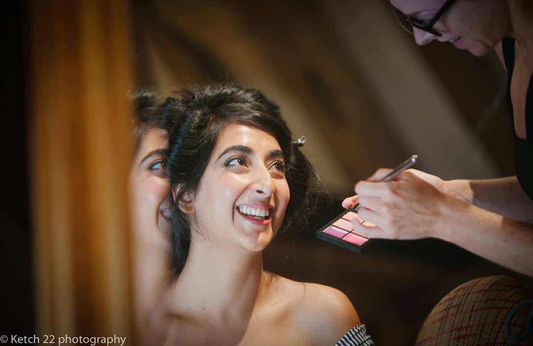 Indian bride in mirror getting ready for Hindu wedding reception at Micklefield Hall