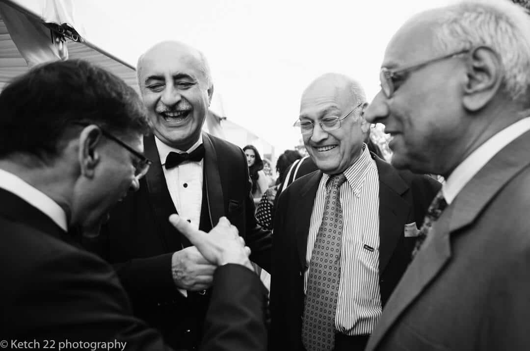 Father of bride and uncles laughing at Hindu wedding