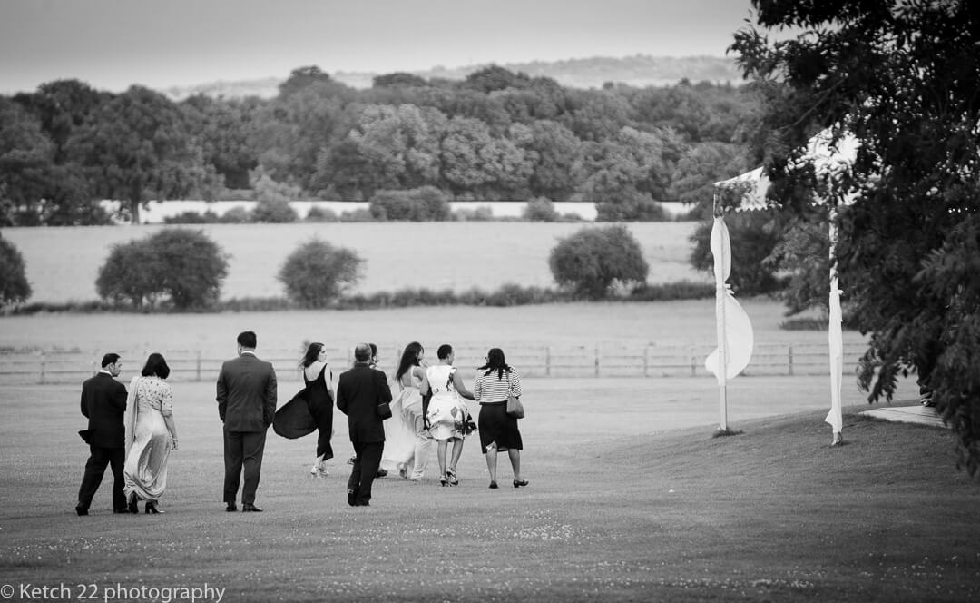 Wedding guests walking to marquee at summer reception