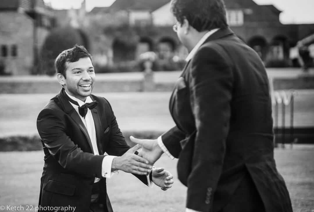 Groom greeting wedding guest at Indian wedding