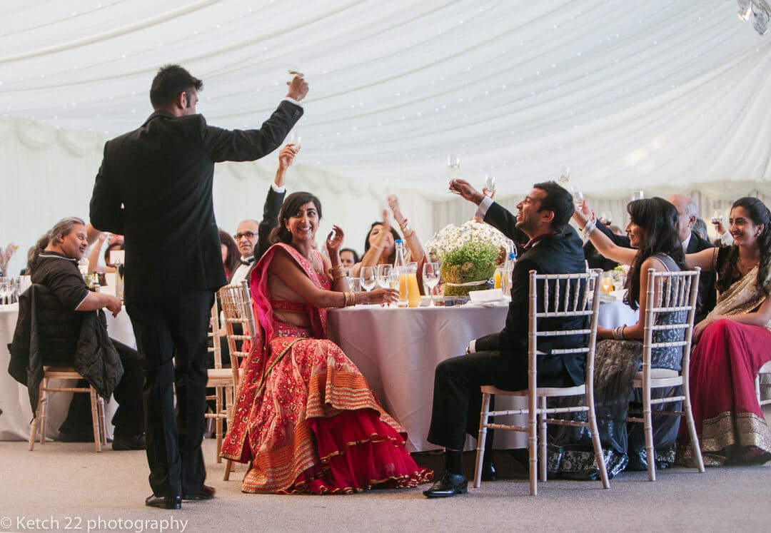Best man and wedding guests toasting at Hindu wedding speeches