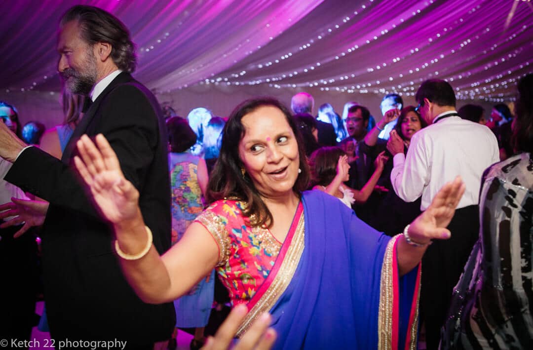 Hindu wedding guest in colourful sari dancing