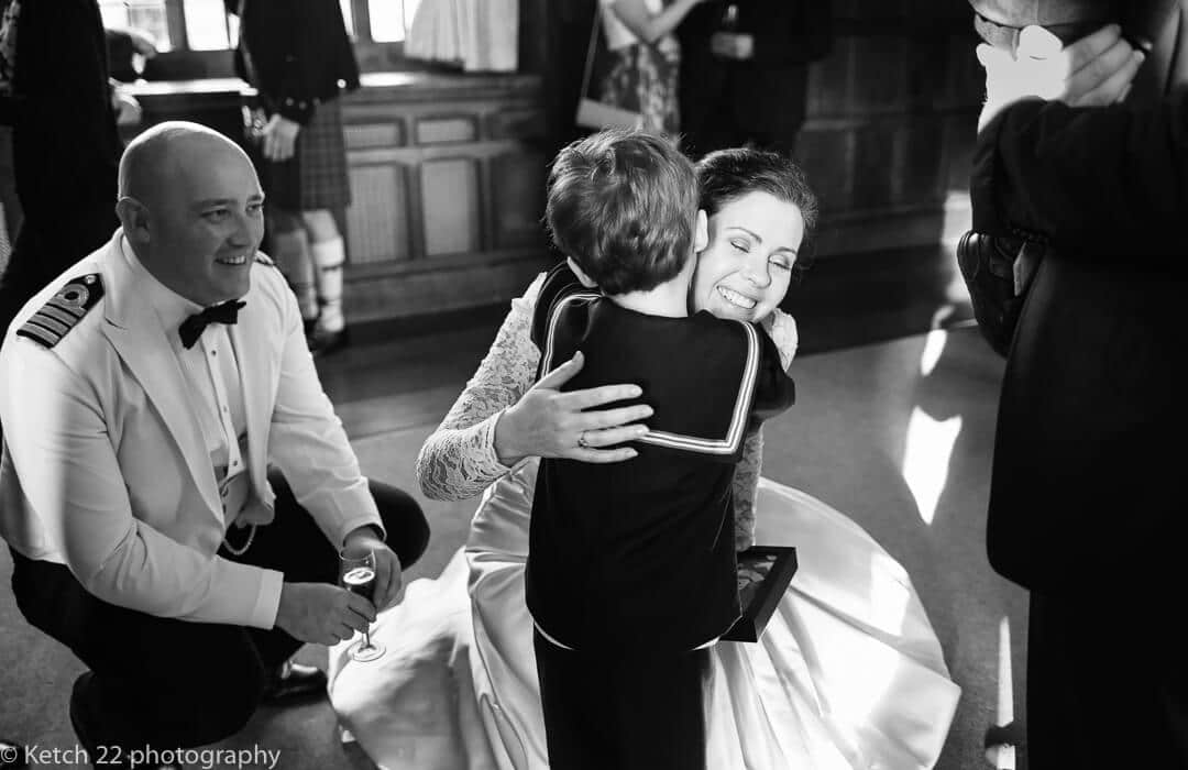 Bride hugging small boy at small wedding