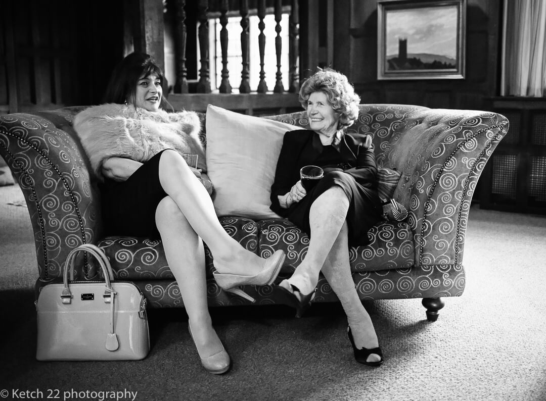 Wedding guests relaxing on sofa and chatting