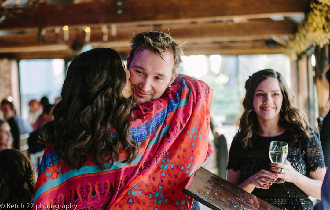 Groom hugging bridesmaid after wedding speech