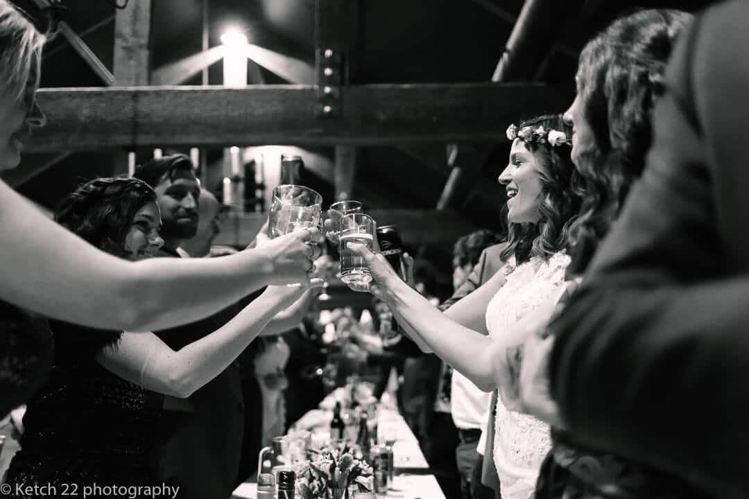 Bride toasting after speeches at barn wedding