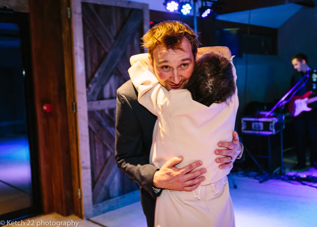 Groom getting hug from grandma at wedding reception