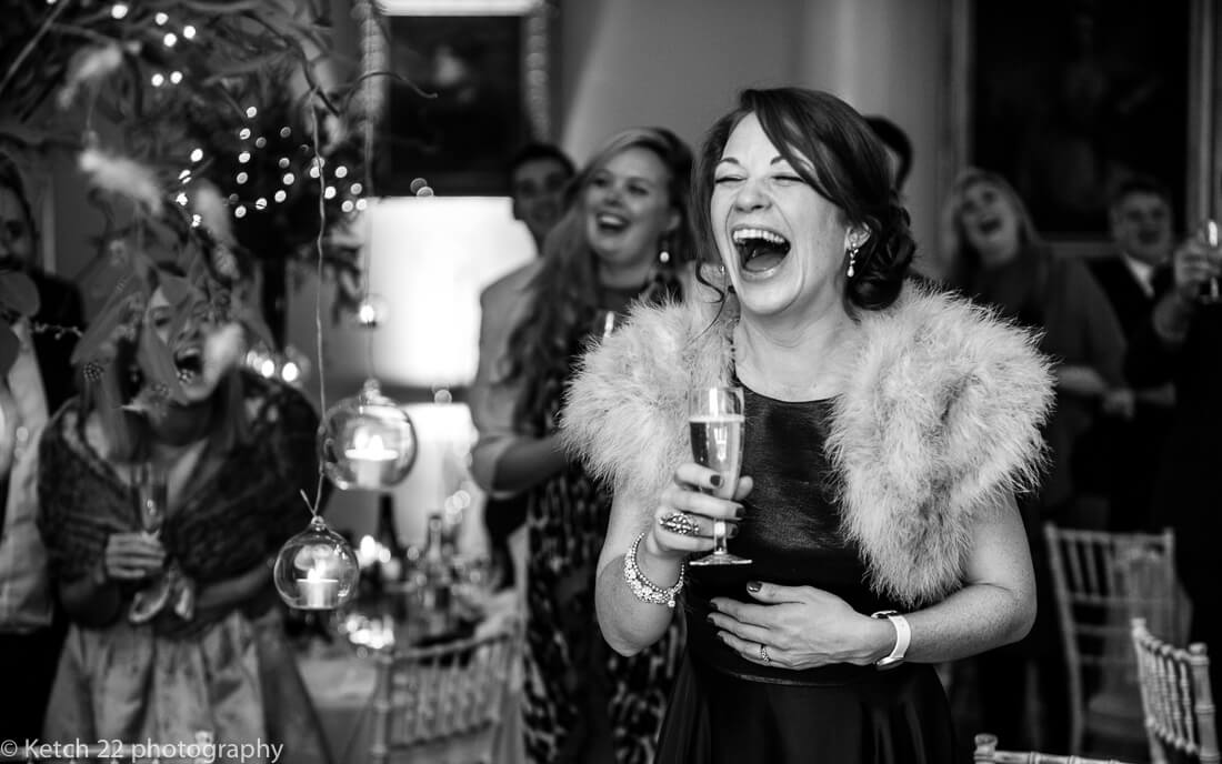 Bridesmaid laughing at speeches at wedding