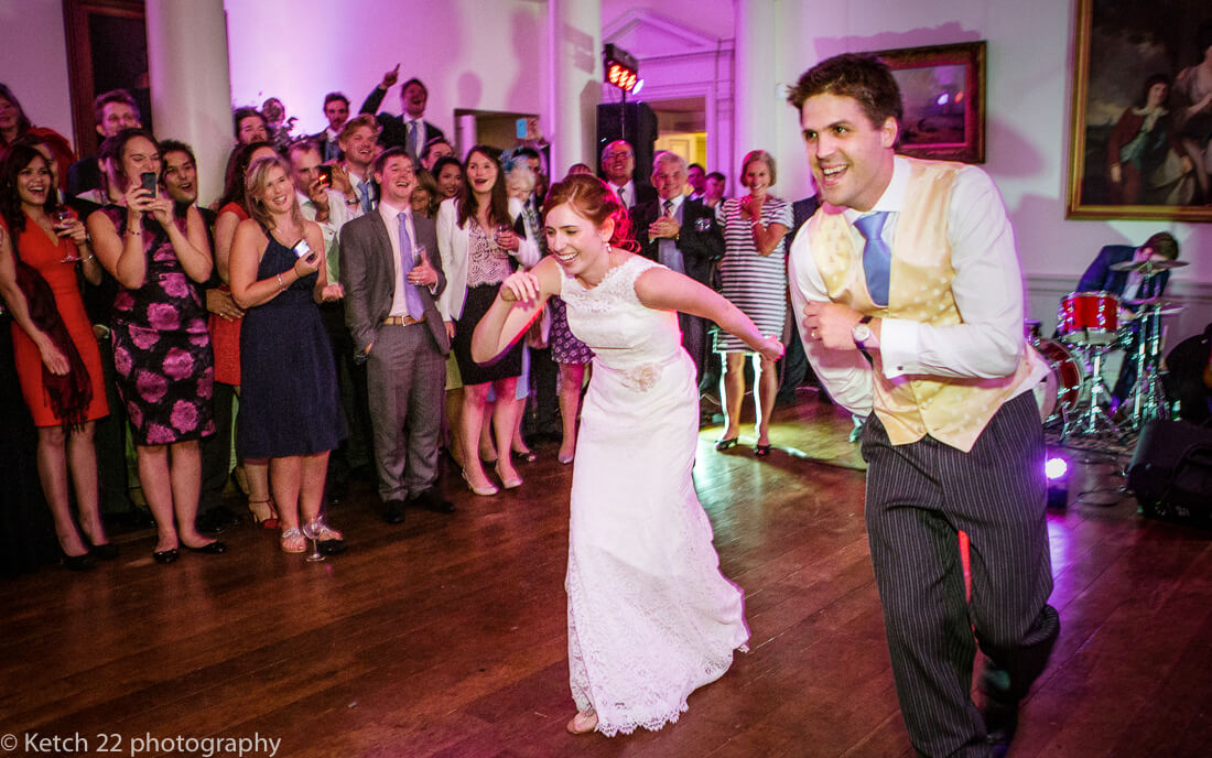 Bride and groom at first dance with cheering wedding guests