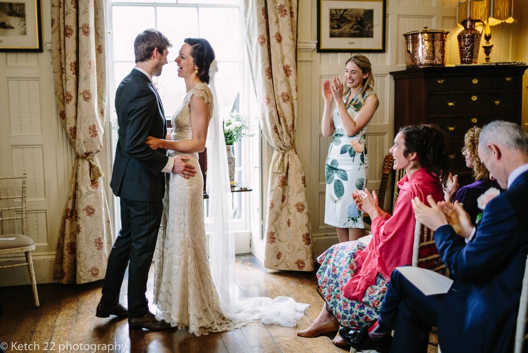 Wedding guests cheering after bride and groom complete vows at wedding ceremony