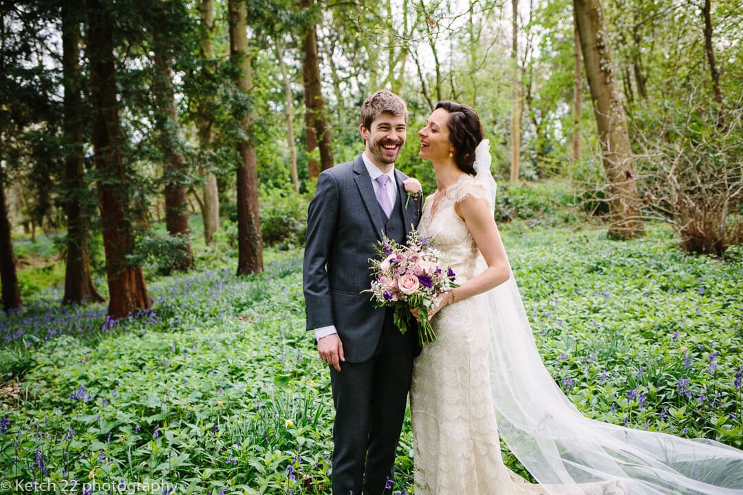 Portrait of bride and groom laughing in the gardens at Spring wedding