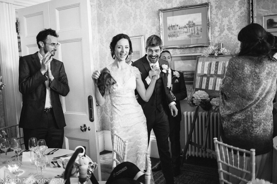 Excited bride and groom enter wedding dinning room at country house wedding