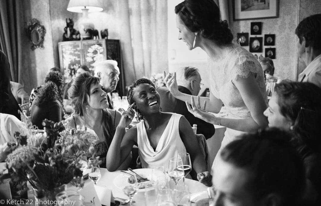 Expressive bride talking to wedding guests during dinner