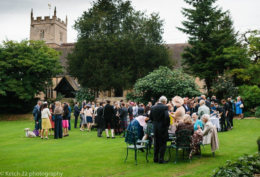 Wedding guests enjoy canapes and drinks on the lawn at Upper Court 