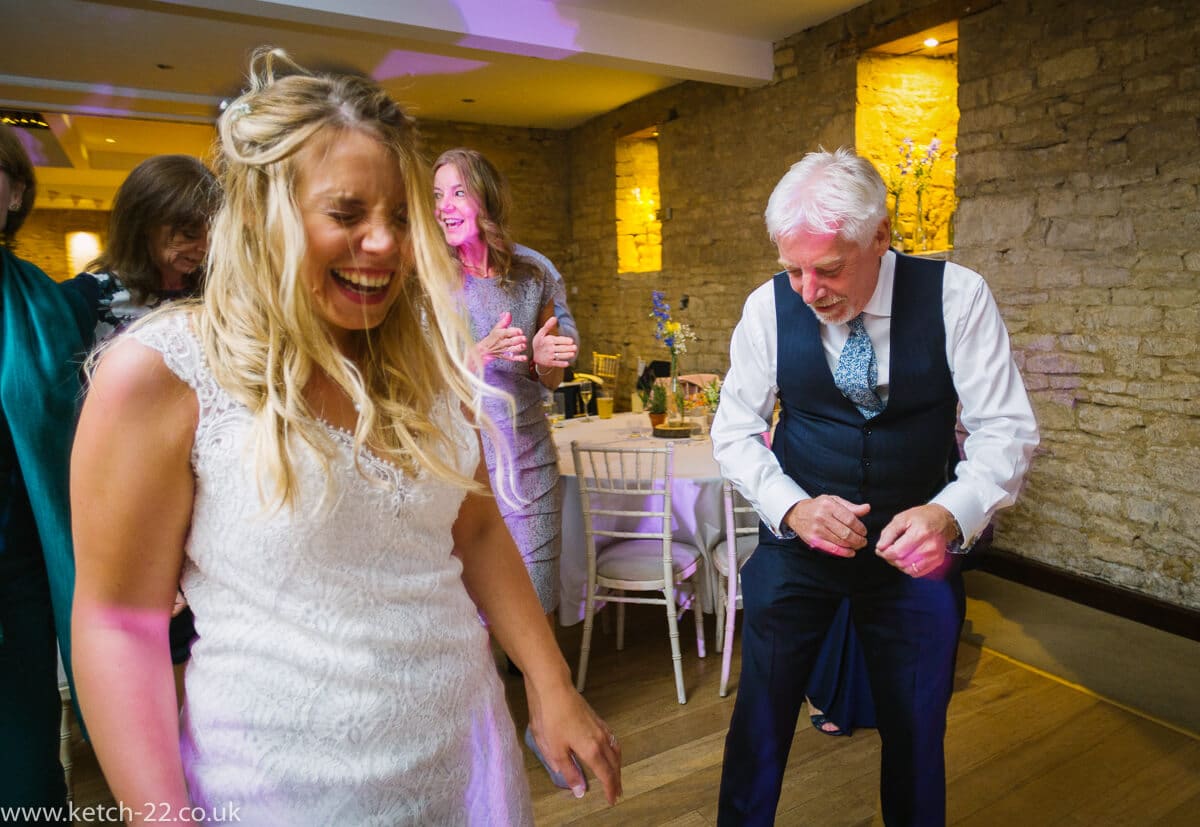 Bride laughing on dance floor at Gloucestershire wedding