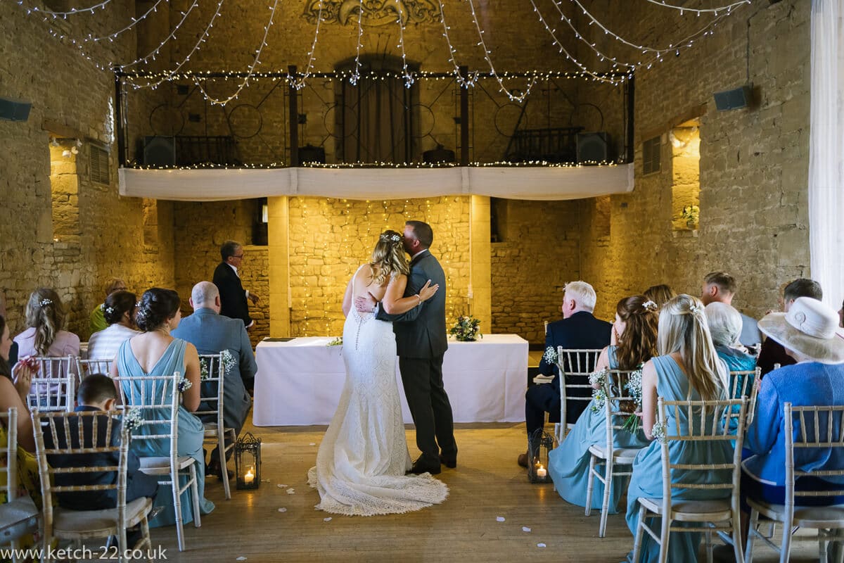 The first kiss at barn wedding ceremony