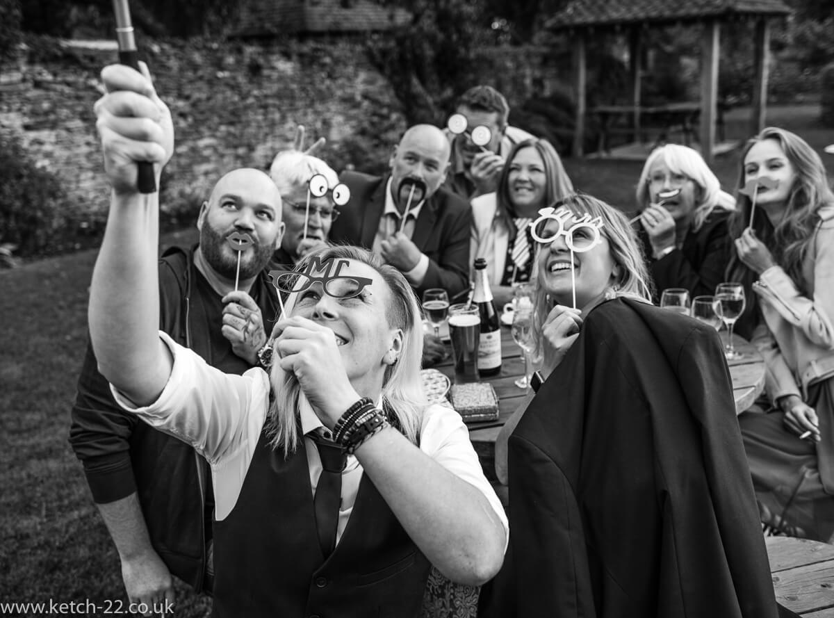 Black and white photo of wedding guests taking selfie
