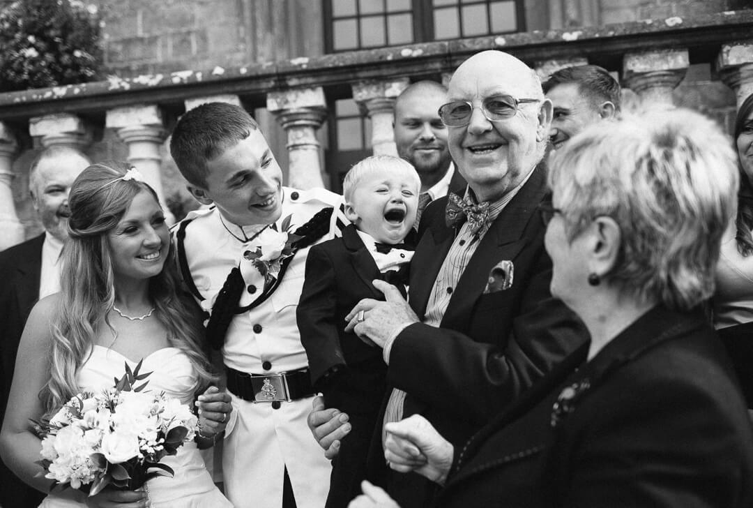 Page boy crying during family photos at wedding