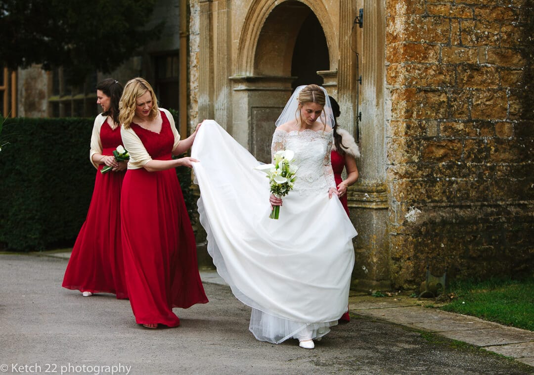 Bride walking with bridemaids in red dresses