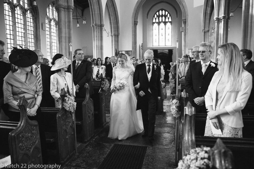 Father and bride walking down Church aisle at church wedding