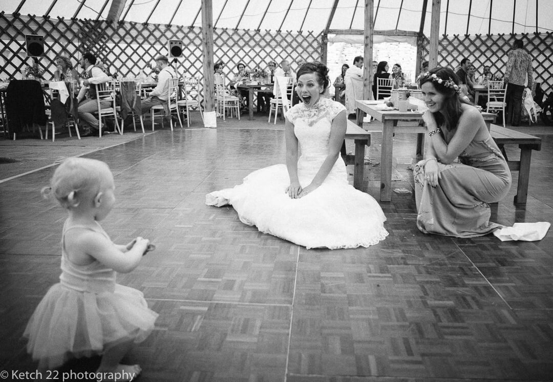 Bride playing with baby at wedding