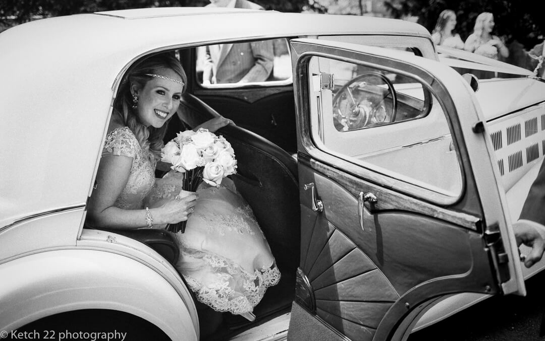 Bride getting out of wedding car 