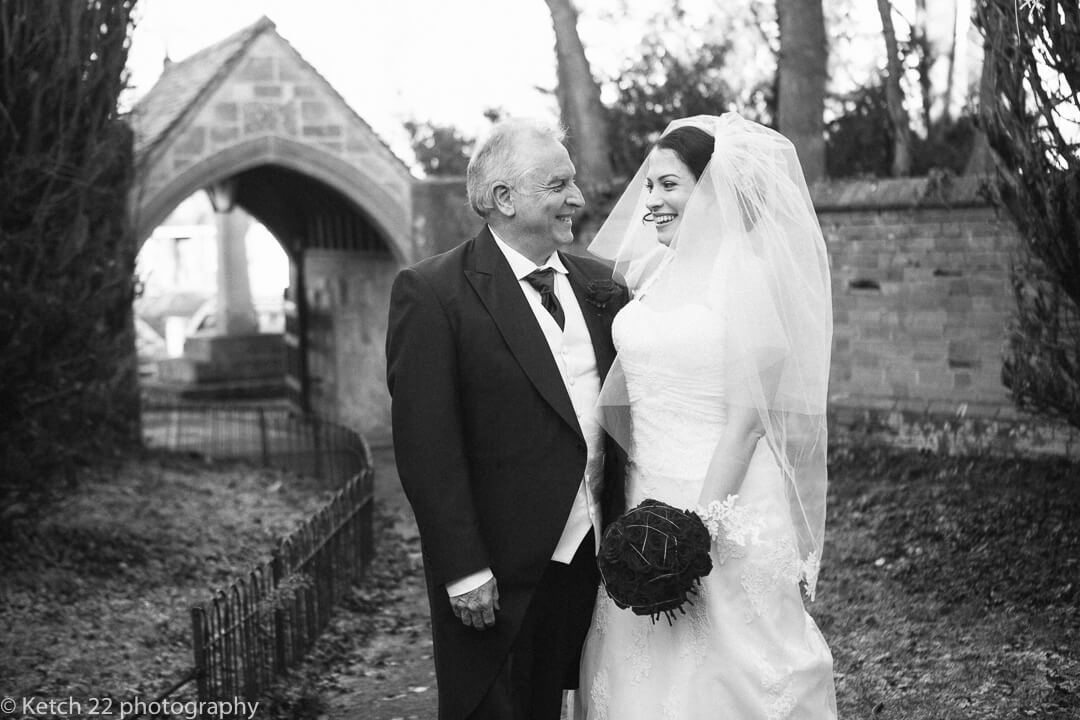 Father and bride looking at each other and laughing and smiling just before wedding ceremony