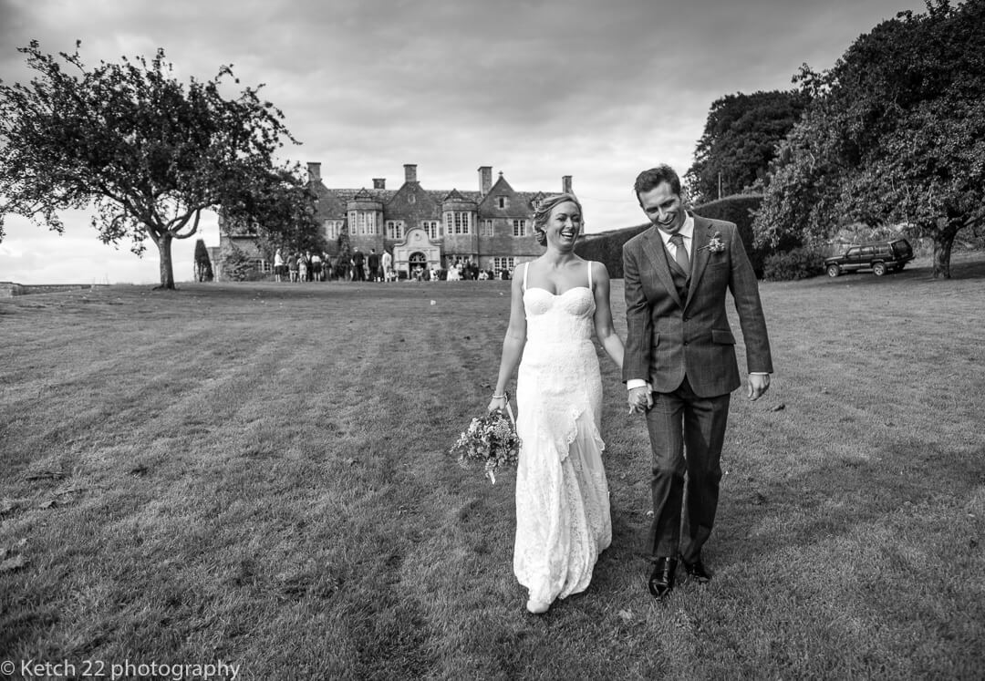 Natural photo of bride and groom walking and laughing in garden
