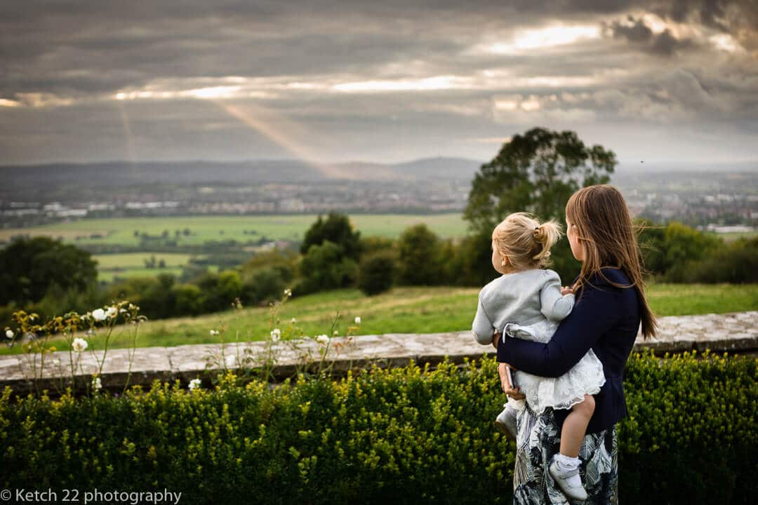 Little girl and big sister overlooking countryside at Gloucestershire wedding