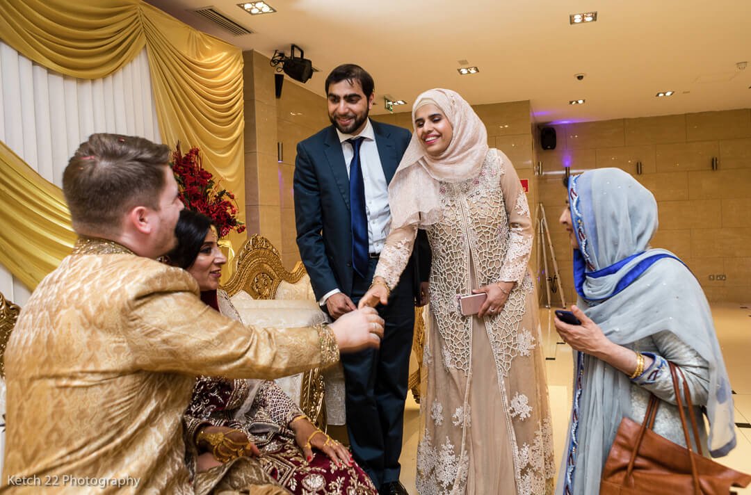 Wedding guests greeting bride and groom at muslim wedding