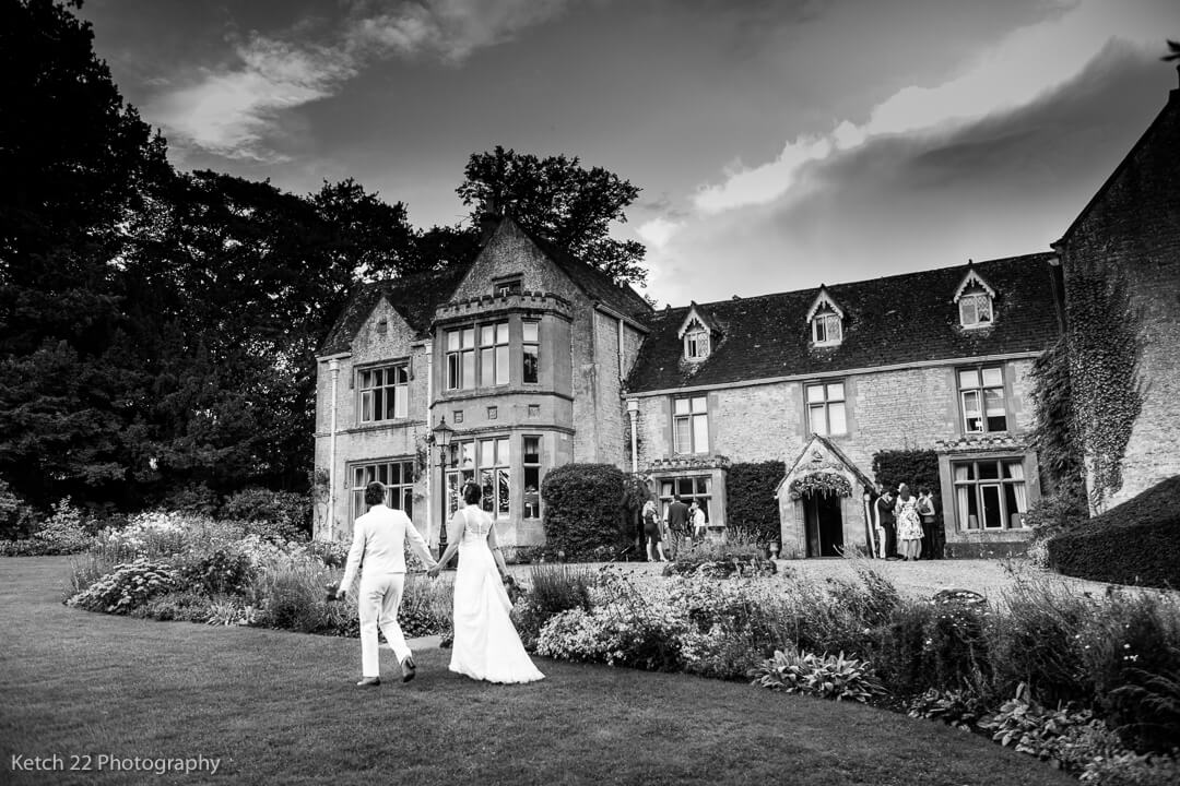 Newly weds walking in front of The Lords of the Manor wedding venue