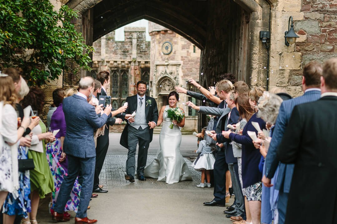 Newly weds getting showered with confetti at Castle wedding