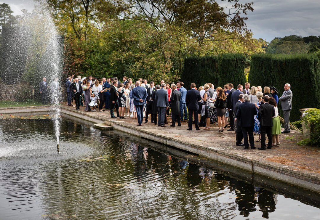 Wedding guests by the fountains at Berkeley castle wedding venue